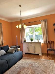 a living room with a blue couch and a window at Ferienwohnung Gänseblümchen in Feistritz an der Gail