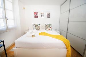 a bedroom with a white bed with an orange blanket on it at Princes Victoria Standing Presta in Cannes