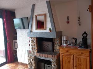 a living room with a fireplace with a tv on it at Appartement chalet en plein centre des Saisies in Hauteluce