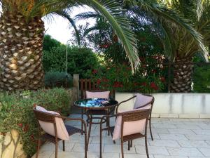 a patio with a table and chairs and a palm tree at Foissner Apartments in Zavalatica