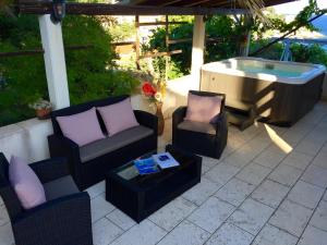 a patio with chairs and a bath tub and a table at Foissner Apartments in Zavalatica