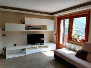 a living room with a tv and a couch at Casa di Bambi in Valdidentro