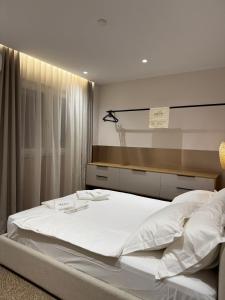 a large white bed in a room with a window at Osik apartments villa 01 in Golem +12 photos