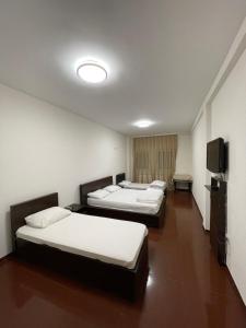 a room with three beds and a flat screen tv at Hotel Iliria in Orllan +14 photos