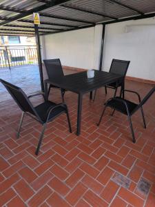 Una mesa negra y dos sillas sobre un piso de ladrillo. en Casacasini 1A, en Málaga 7 fotos más