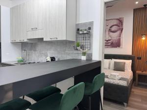 cocina con encimera y 2 sillas verdes en Aragon Cottage Apartments, en Le Castella