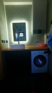 a bathroom with a mirror and a washing machine at Mazurskie Wzgórze Nad Jeziorem Isąg in Pelnik +46 photos