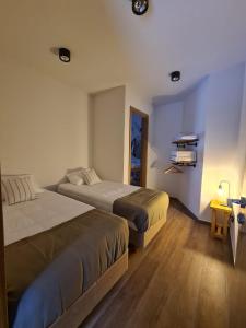 a hotel room with two beds and a mirror at Wenuk Patagonia in San Carlos de Bariloche