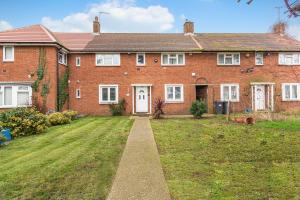 a large red brick house with a grass yard at Spacious 3BHK near Heathrow in Cranford