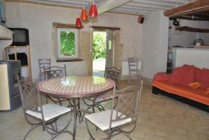 une salle à manger avec une table, des chaises et un canapé dans l'établissement Yourte Bourgogne, à Corvol-dʼEmbernard