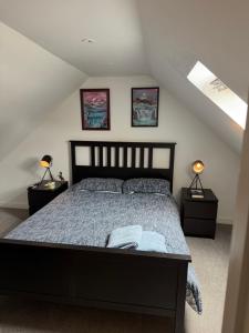 a bedroom with a bed with two night stands and two lamps at Palmiro Cottage in Lapford