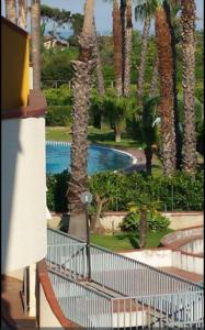 a view of a resort with a pool and palm trees at Oasis House in Acireale