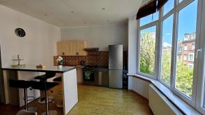 a kitchen with a counter and a large window at Suite Diamant - Chic & Lumineux in Brussels