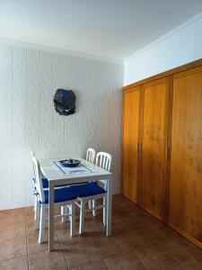 a kitchen with a table and chairs and a cabinet at Villa Nenúfares in Torreira