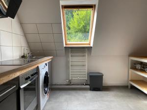 eine Küche mit Waschmaschine und Fenster in der Unterkunft Großzügige Ferienwohnung zwischen Bremen und Hamburg in Alfstedt