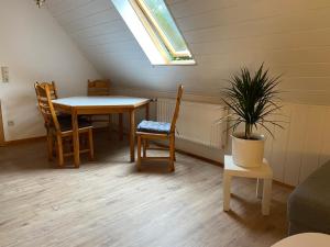 ein Esszimmer mit einem Tisch, Stühlen und einer Pflanze in der Unterkunft Großzügige Ferienwohnung zwischen Bremen und Hamburg in Alfstedt