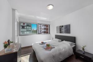 Un dormitorio blanco con una cama y una ventana. en Art Apartment - Happy Rentals, en Locarno