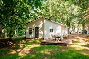 a white shed with a table and chairs on a deck at Arbutus Lake-King Suite-Pontoon Rentals in Traverse City