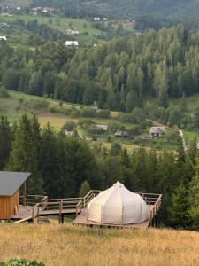 ein großes weißes Zelt auf einem Feld mit einem Hügel in der Unterkunft Glamp Shepit in Shepot