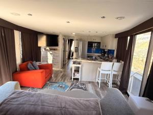 a living room with a red couch and a kitchen at b3 Couples Therapy Yacht in La Crosse