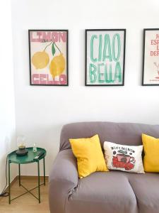 a couch in a living room with pictures on the wall at Casa Genzino in Molfetta