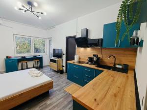 a room with a bed and a kitchen with blue cabinets at Botev Design Apartments - Walk to Old Town - Pumo Properties in Bucharest