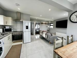 a kitchen and living room with a clock on the wall at The Ocean Nest in Loughaunbeg
