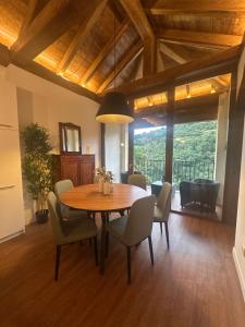 una sala da pranzo con tavolo e sedie in legno di La Rectoral de Besullo a Besullo