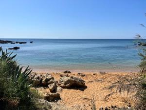 a sandy beach with the ocean in the background at Bungalow tra natura e mare in Capo Colonna