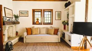 a living room with a couch and a television at Quinta de Valverde in Viana do Castelo