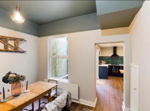 a dining room with a table and a kitchen at 4 Bedroom Belfast Townhouse in Belfast +7 photos