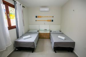 a room with two beds and a window at Casa_Mare11 in São Miguel do Gostoso