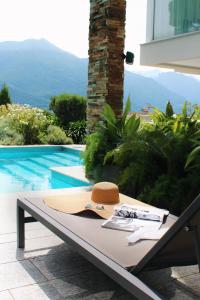 a table with a surfboard on it next to a pool at Villa Koi - where luxury meets serenity in Pianello Del Lario +41 photos