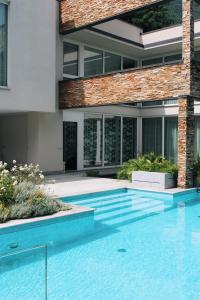 a house with a swimming pool in front of a building at Villa Koi - where luxury meets serenity in Pianello Del Lario