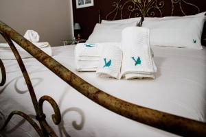 a bed with white blankets and towels on it at A Casa da Nelly Augusta in Augusta