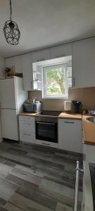 a kitchen with white cabinets and a sink and a window at Holiday Home Krejović in Žabljak