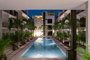 a swimming pool in the middle of a building at Otonomus Tulum in Tulum