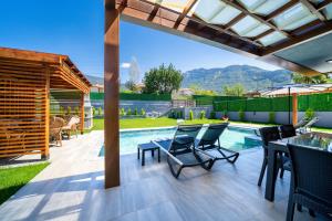 un patio con tavolo e sedie e una piscina di Villa TURK a Fethiye