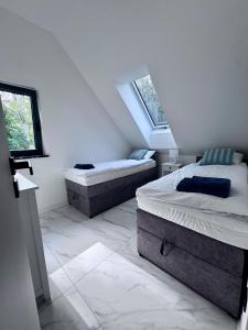 twee bedden in een kamer met twee ramen bij Marina Dziwnow Premium Haus in Dziwnów