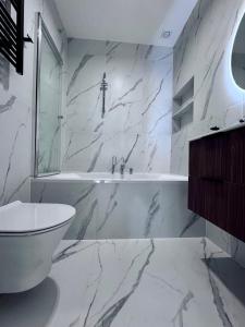 een witte badkamer met een bad en een toilet bij Marina Dziwnow Premium Haus in Dziwnów