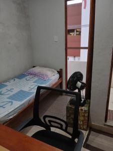 a small room with a bed and a chair at Pousada Familiar 31 in Campos dos Goytacazes