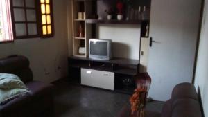a living room with a couch and a tv at Pousada Familiar 31 in Campos dos Goytacazes