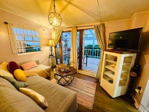 a living room with a couch and a flat screen tv at Casita Orquidea in Resolution +27 photos