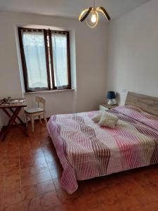 a bedroom with a bed and a table and a window at Il Fienile in Casole dʼElsa +13 photos