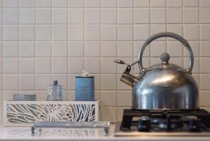 a tea kettle sitting on top of a stove at Arch Window garden apartment in Stellenbosch +33 photos