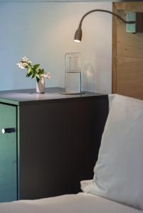 a bedroom with a bed with a nightstand with a glass appliance at Arch Window garden apartment in Stellenbosch