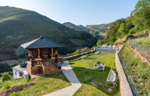 un piccolo edificio su una collina con un campo erboso di La Rectoral de Besullo a Besullo