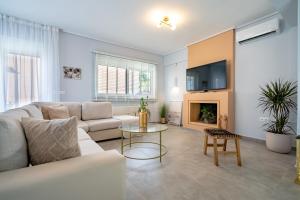 Una sala de estar con un sofá y una chimenea. en Villa Mareluna by Traser, en Artemida