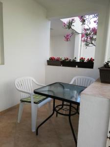 a dining room with a table and two chairs and flowers at Apartment Aleksic Becici in Bečići