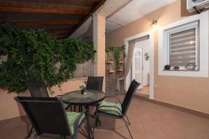 a patio with a table and chairs and a plant at Apartments Ivana in Nin